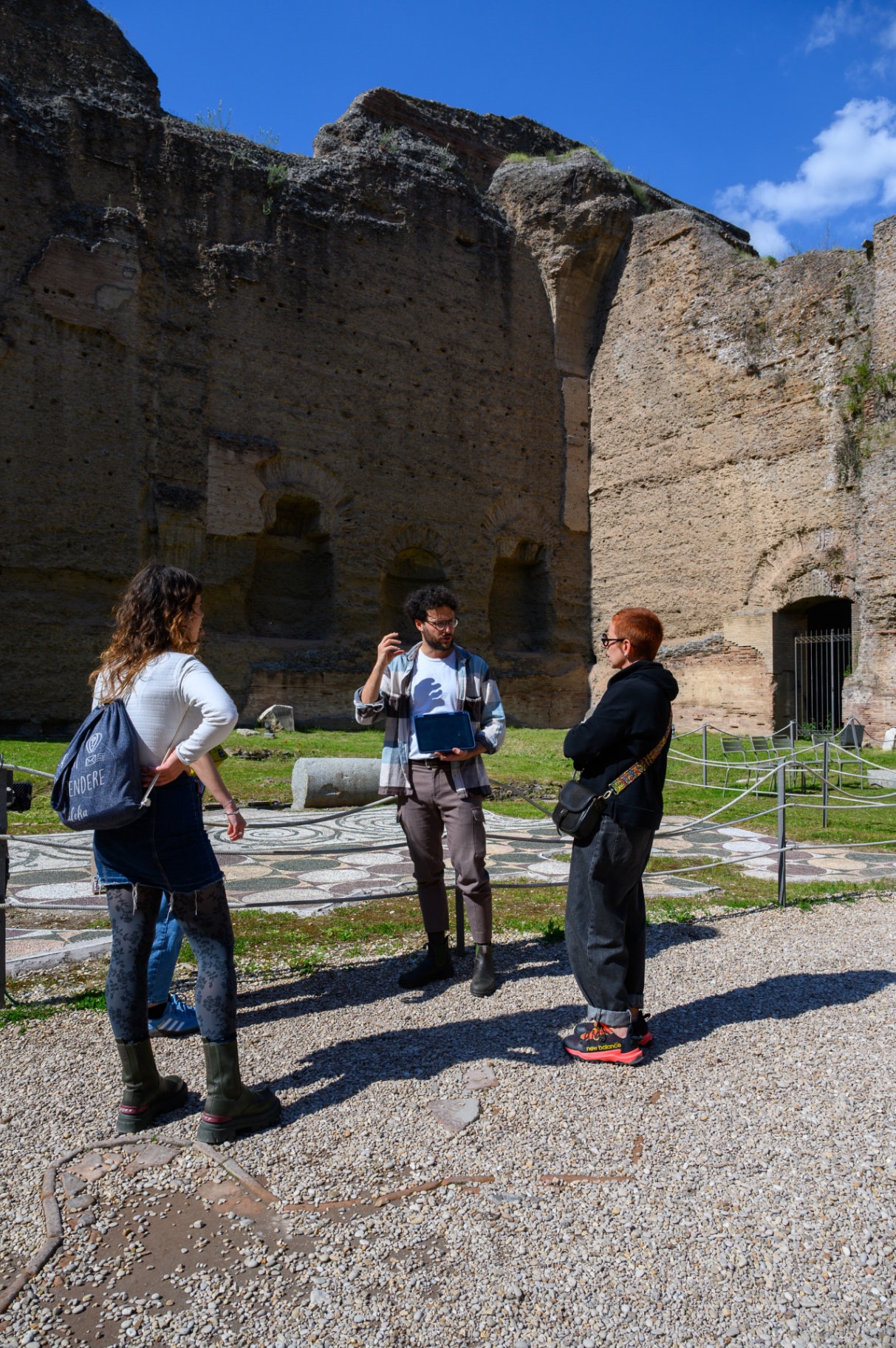 Guide explaining the site in a sunlit archaeological courtyard
