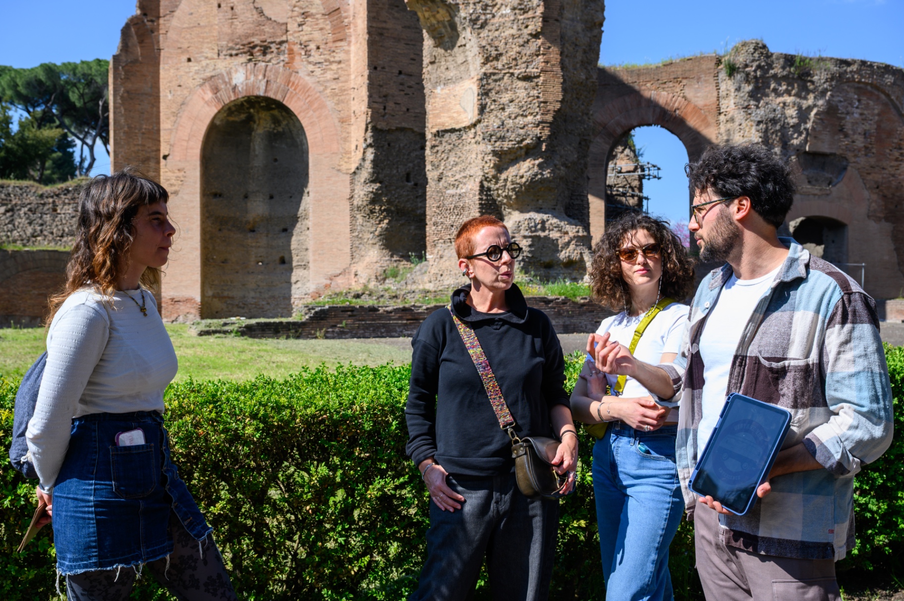 Small group listening to the guide among Appian Way ruins