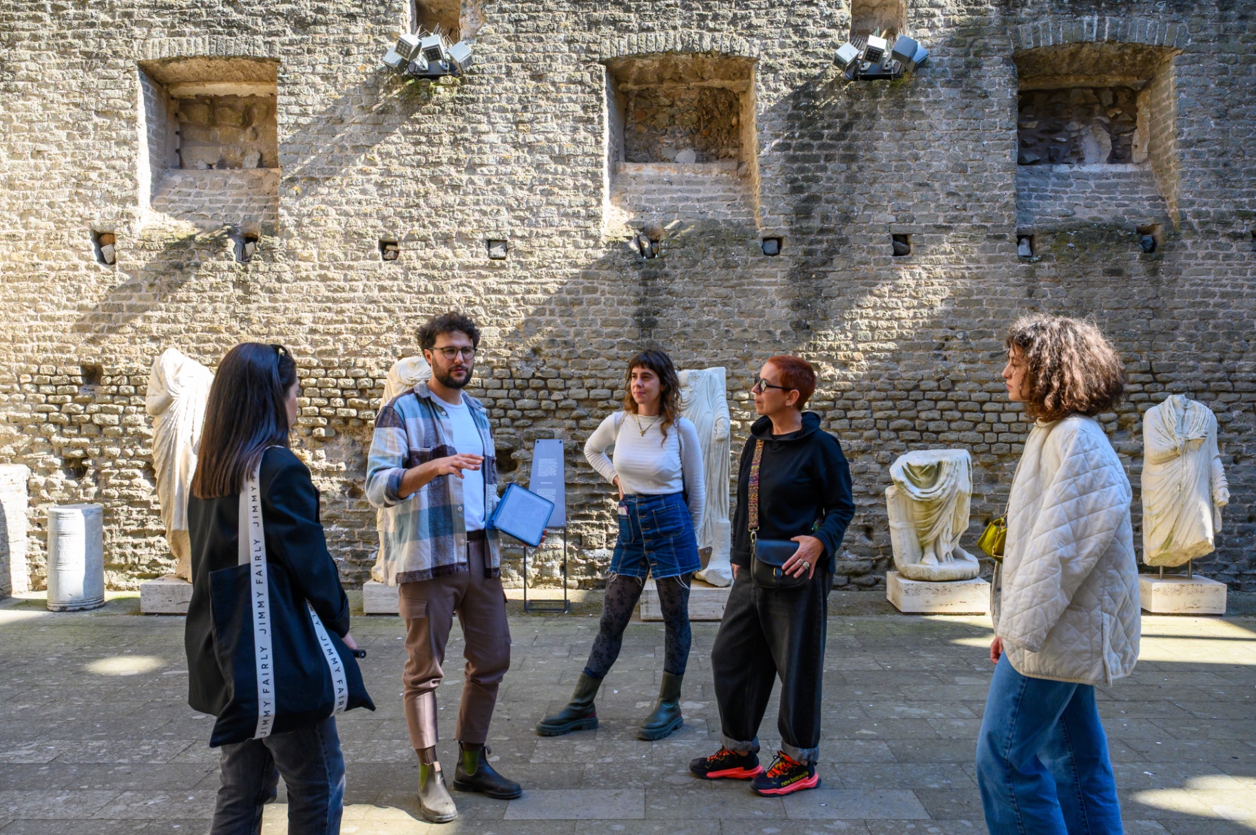 Guests exploring a sculpture-filled archaeological room